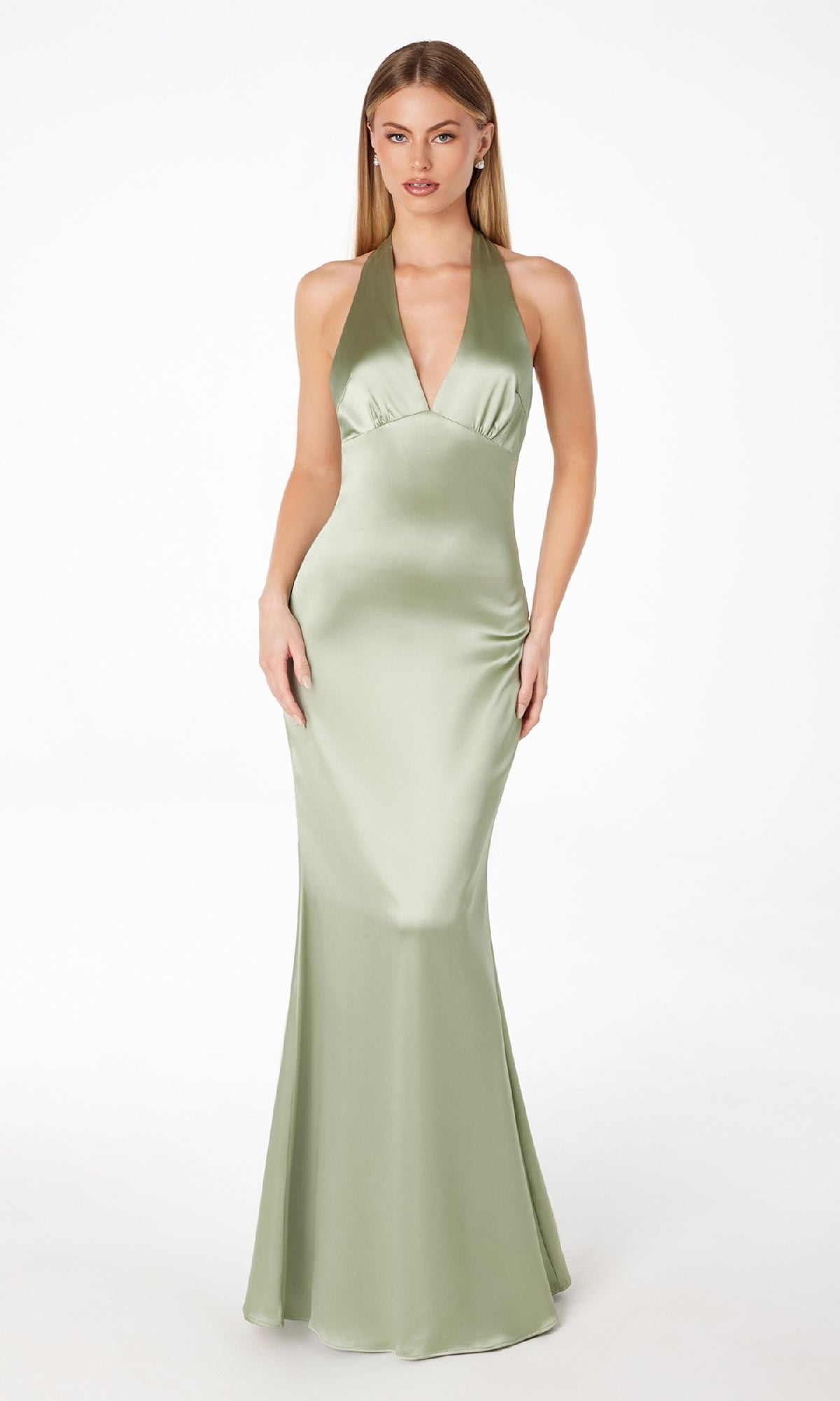 A woman stands against a white background wearing the Bow-Back Long Satin Halter Prom Dress: Astee T2001, featuring a light green hue, fitted bodice, flared hem, and elegant halter neckline.